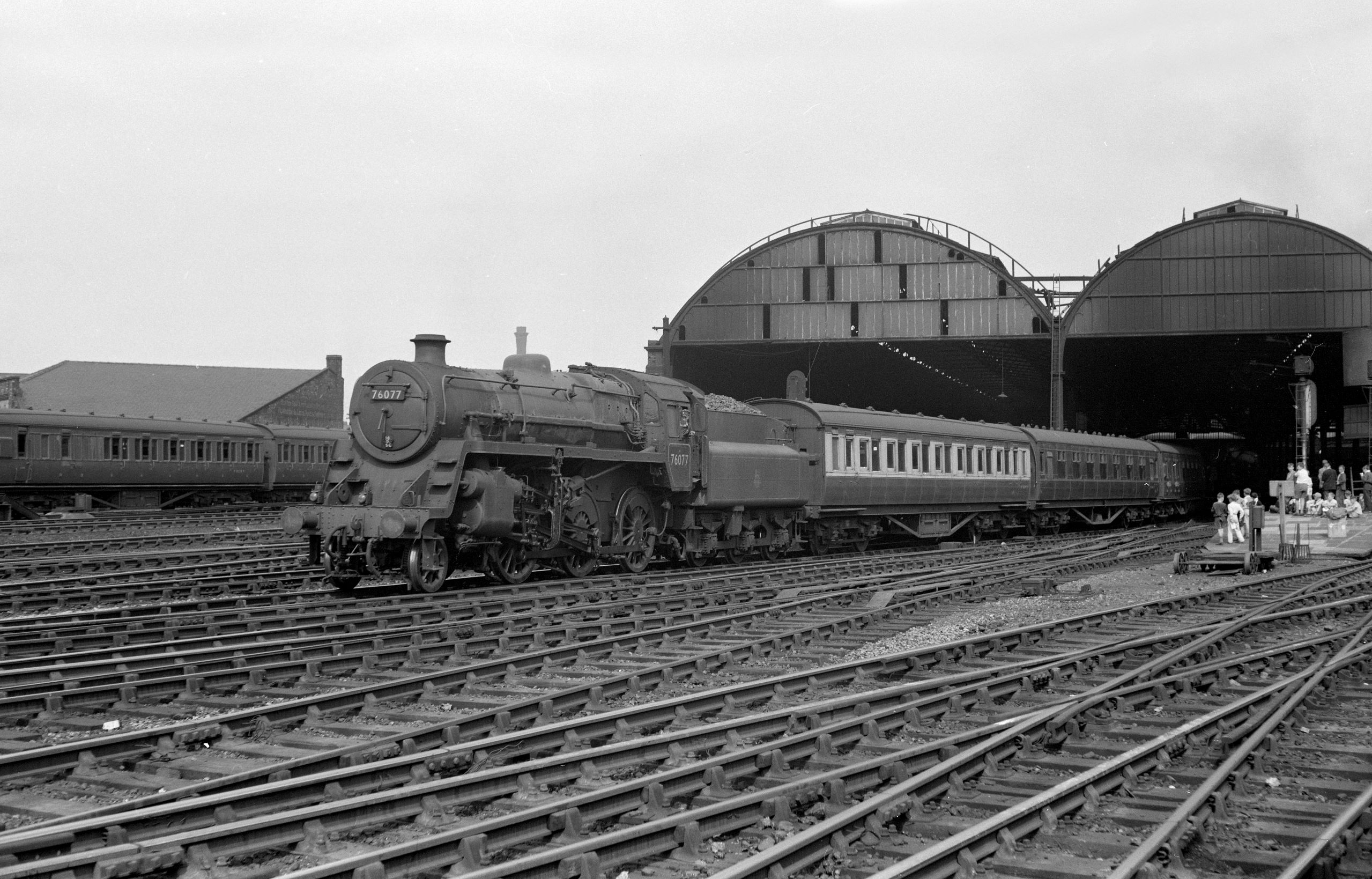 76077 makes a gentle start from Manchester Exchange watched by a flock of trainspotters with empty stock on 3 August 1957